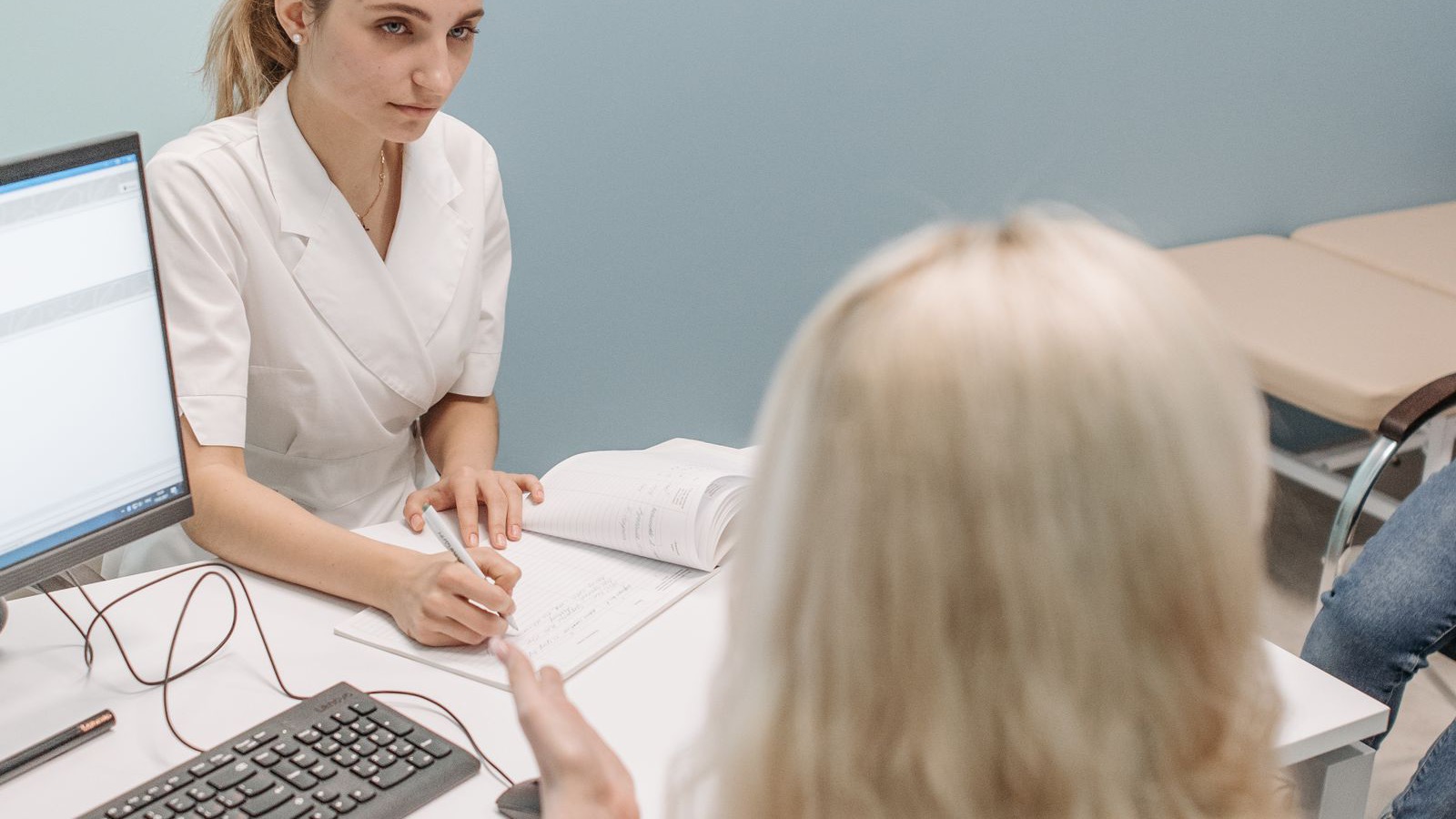 Un profesional de salud conversa con una persona en una consulta